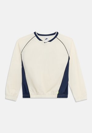 Wit en marineblauw Nike sportshirt met lange mouwen, elastische manchetten en een ronde hals, afgebeeld op een effen achtergrond.
