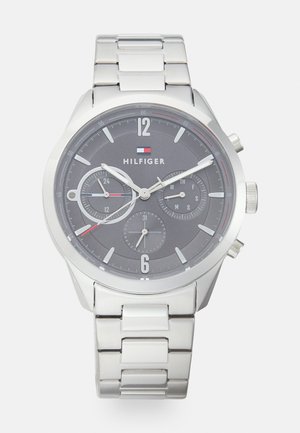 Montre chronographe en acier inoxydable argenté avec un cadran gris foncé, trois sous-dials et des marqueurs d'heure argentés. Dotée d'un bracelet en métal.