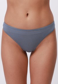 Világosszürke pamut bikini alsó, sima textúrával, alacsony derekú dizájnnal és tiszta, befejezett szélekkel. Minimalista stílus, látható minták nélkül.