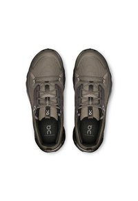 Chaussures de sport en maille grises avec un bout rond, des lacets et des détails de logo ; tige texturée avec une semelle rembourrée et des accents sombres contrastants.