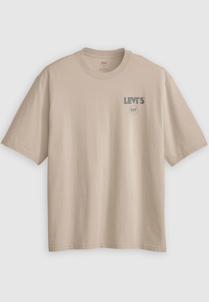 Beige puuvillainen t-paita, jossa on lyhyet hihat, pyöreä pääntie ja "Levi's 501" -logo harmaana painettuna vasemman rinnan yläosassa. Sileä pinta.