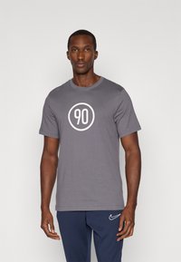 T-shirt in cotone grigio con un grande cerchio bianco al centro contenente il numero "90", maniche corte e design a girocollo.