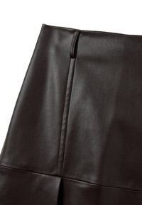 Bruine lederen rok met een gladde textuur, voorzien van een zijsplit en naaddetails, ontworpen om nauwsluitend te passen rond de taille en heupen.