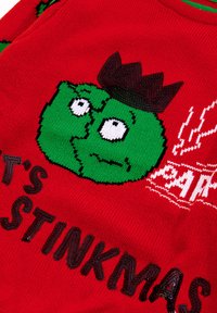Czerwona sweter dziergany z zielonym rysunkowym bohaterem w koronie, towarzyszący napis "To są Stinkmas" w czarnych i białych akcentach.