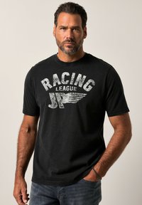 Černé bavlněné tričko s krátk�ým rukávem, na přední straně s opotřebovaným bílým grafickým potiskem s nápisem "RACING JP LEAGUE". Jednoduchý design s kulatým výstřihem.