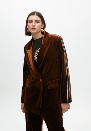 Brown velvet blazer featuring a double-breasted design, side pockets, and white and black stripes along the sleeves.