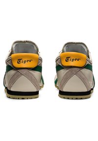 Beżowo-zielone skórzane buty z zamszowymi akcentami, z żółtą kapsułą na obcasie i czarną podeszwą. Napis "Tiger" na obcasie.