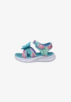 Sandalo per bambini con cinturini glitter rosa, turchese e viola, dettaglio farfalla, velcro regolabile e suola bianca imbottita.