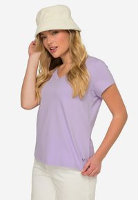 T-shirt à manches courtes V-neck violet clair, fabriqué en tissu doux, avec un détail logo discret à l'ourlet et une coupe décontractée.