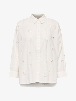 Fehér, hosszú ujjú, gombos ing virágmintás kivágott hímzéssel, galléros nyakkivágással és enyhén íves szegéllyel.