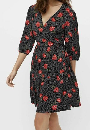 Robe portefeuille noire à pois blancs et motif floral rouge, avec des manches trois-quarts et un ourlet à hauteur du genou.