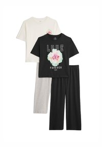 Twee t-shirts in beige en zwart, met bloemenontwerpen en bedrukte tekst, gecombineerd met grijs en zwart wijde broek. Katoenen materiaal.