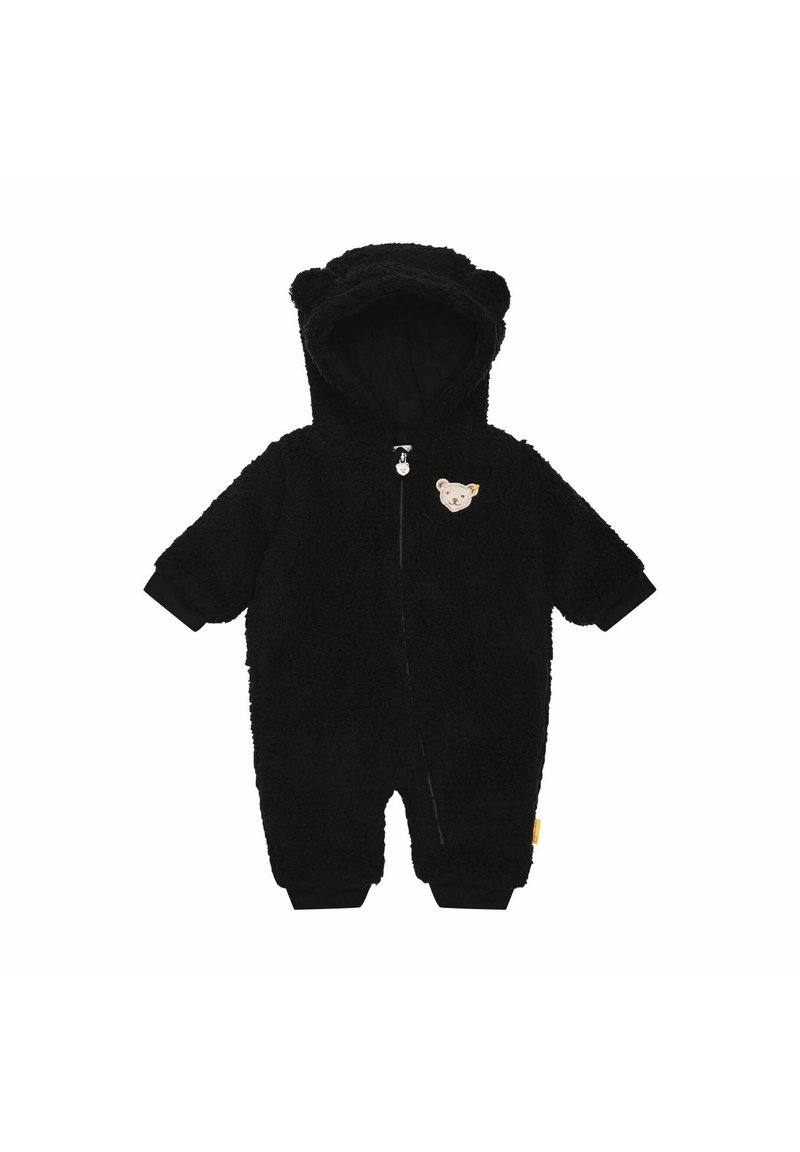 Schwarzer Fleece-Overall mit Kapuze, die Bärenohren zeigt, einem Reißverschluss vorne und einem Bären-Patch auf der Brust. Die Bündchen sind schwarz und enganliegend.