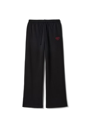 Pantalones de chándal negros con un ajuste holgado, cintura elástica, cordón ajustable y texto bordado en rojo en el lado izquierdo. Textura de tela suave.