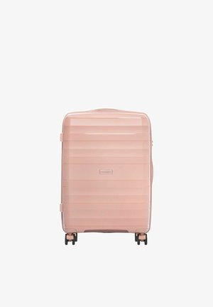 Twarda walizka w jasnoróżowym kolorze z poziomymi żeberkami, czterema czarnymi obracającymi się kółkami i górnym uchwytem.