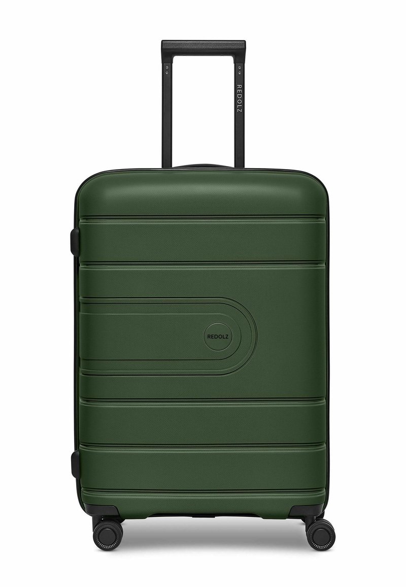Valigia rigida verde con superficie texturizzata, scanalature orizzontali e un logo circolare. Presenta un manico estraibile nero e ruote.