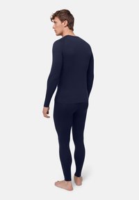 Marineblaues langärmliges Thermoshirt und passende Leggings aus einem weichen, dehnbaren Stoff mit glatter Oberfläche und minimalen Nähten.