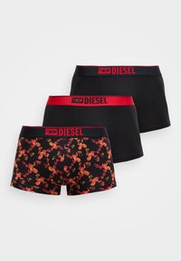 Trei perechi de boxeri pentru bărbați. Una cu un model floral în roșu și negru, și două complet negre cu talie roșie cu logo Diesel.