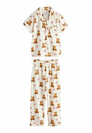 Cremefarbener kurzärmeliger Pyjama mit Knopfleiste und Hose mit braunen Teddybär- und roten Schleifenmustern, mit Brusttasche am Oberteil.