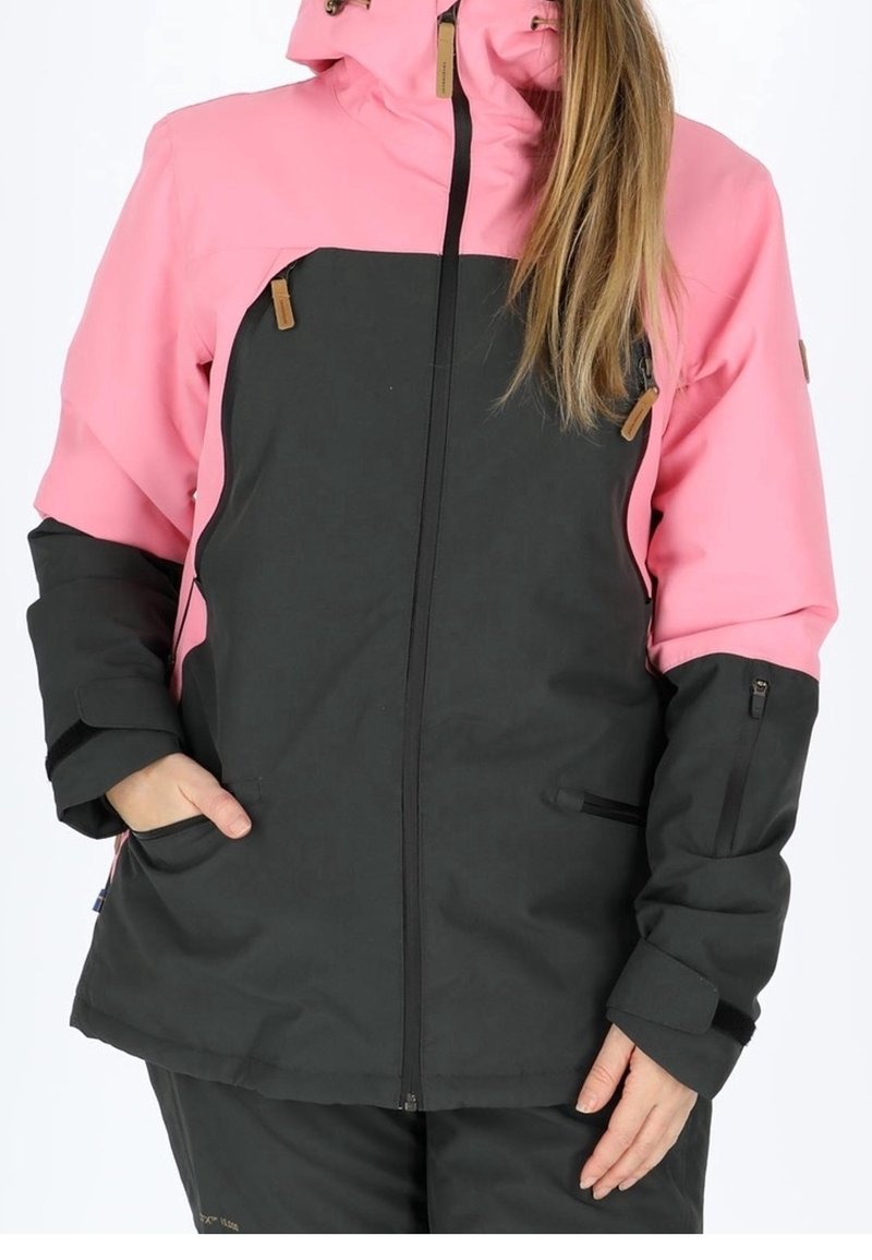 Veste imperméable avec un corps noir et des manches roses. Dotée d'une fermeture éclair à l'avant, d'une capuche ajustable et de plusieurs poches de rangement.