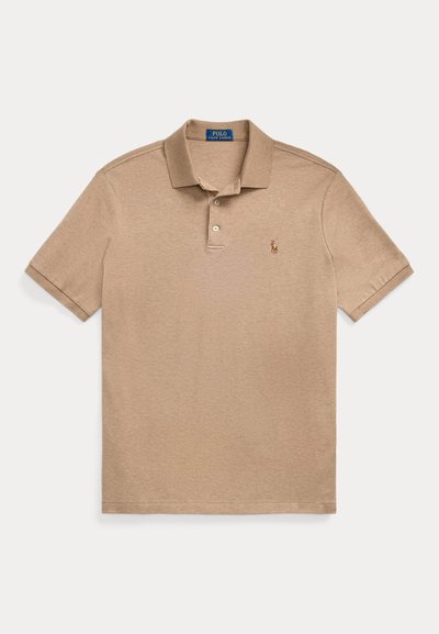 Beige polo-skjorte laget av bomull, med en tre-knappers krage, korte ermer og en liten brodert logo på venstre bryst.