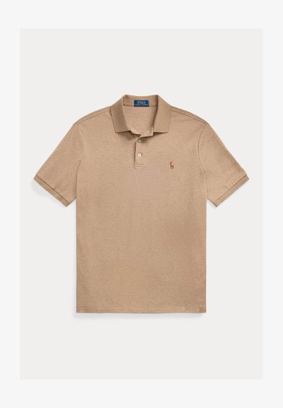 Beige polo-skjorte laget av bomull, med en tre-knappers krage, korte ermer og en liten brodert logo på venstre bryst.