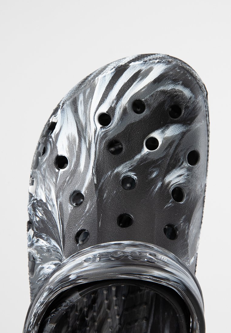 Sabots marbrés noir et blanc avec une surface texturée, plusieurs trous de ventilation et une large sangle autour du haut, fabriqués en matériau léger.