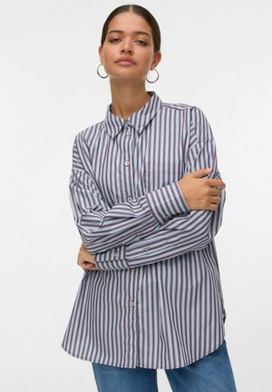 Gestreepte langemouwen shirt in paars, blauw en wit. Heeft een kraag, knoopsluiting aan de voorkant en een enkele borstzak. Zachte, gladde stof.