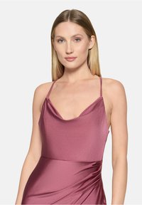 Robe à col bénitier en tissu mauve doux et scintillant, avec des bretelles fines ajustables et un détail de drapé sur le côté.