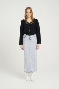 Svart ribbet strikket cardigan med store knapper, kombinert med et lys blått denim maxi-skjørt. Har hvite spisse ankelstøvletter.