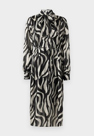 Crno-bijela haljina dugih rukava s uzorkom zebra, visokim izrezom i detaljem mašne na ovratniku. Mekana, lepršava tkanina s remenom u struku.