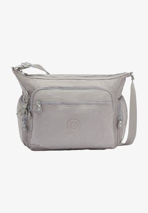 Light gray nylon crossbody bag with multiple zippered compartments, adjustable strap, and round logo patch on the front.