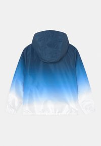 Chaqueta con capucha en degradado azul, que transita de un navy oscuro a un azul claro, con puños elásticos y una textura suave y brillante.
