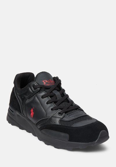 Svart sneaker med en kombination av läder och mocka. Har en mesh-tåbox, tjock sula, svarta snören och röd Polo-logotypdetalj.
