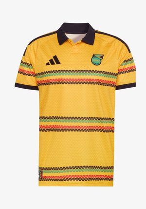 Κίτρινη ποδοσφαιρική φανέλα πόλο με μαύρο γιακά, οριζόντιες ρίγες σε κόκκινο, πράσινο και μαύρο, λογότυπο Adidas και σήμα της Ομοσπονδίας Ποδοσφαίρου της Τζαμάικα.