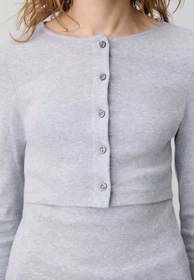 Maglione corto grigio realizzato in morbido tessuto, dotato di scollo rotondo e chiusura a bottoni sulla parte anteriore, con sei bottoni decorativi.