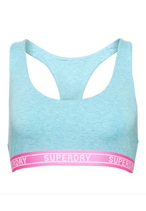 Sujetador deportivo azul claro con escote en forma de barco y diseño de espalda cruzada. Presenta una banda con el logotipo en rosa "SUPERDRY" en la parte inferior. Material suave y elástico.