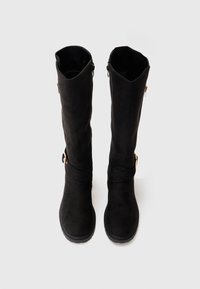 Schwarze Wildleder-Stiefel bis zum Knie mit einer runden Zehenform, seitlichen Reißverschlüssen und dekorativen goldfarbenen Hardware-Accents. Glatte Textur mit einer robusten Sohle.