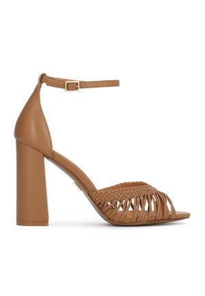 Sandale à talon haut en cuir fauve avec un design de brides tressées, une boucle à la cheville et un talon bloc épais. Texture lisse avec un bout ouvert.