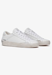 Witte sneakers met een gladleren bovenkant, geborstelde suede accenten, platte veters en een rubberen buitenzool. Heeft een minimalistisch ontwerp met subtiele branding.