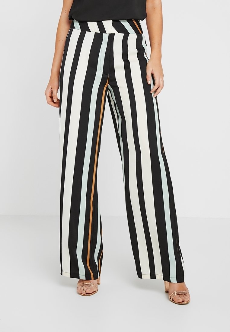 Pantalons larges avec des rayures verticales en noir, blanc, bleu clair et marron. Fabriqués dans un tissu lisse avec une taille haute.