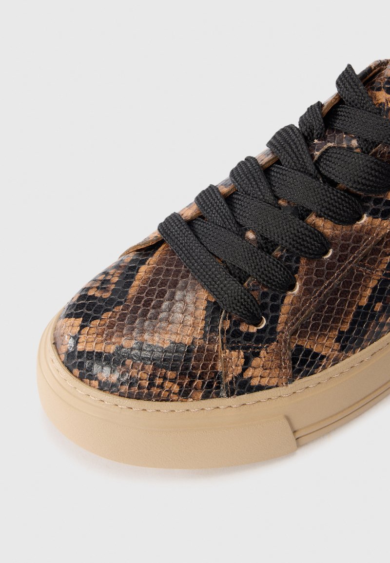 Sneaker im Schlangenprint in Braun und Schwarz mit einem Obermaterial aus strukturiertem Leder, schwarzen Schnürsenkeln und einer tanfarbenen Gummisohle. Abgerundete Zehenform und lässiges Design.