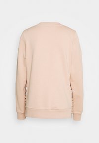Lichtroze sweatshirt met een ronde hals, ribgebreide manchetten en zijdetails met een gerimpeld patroon voor extra textuur.
