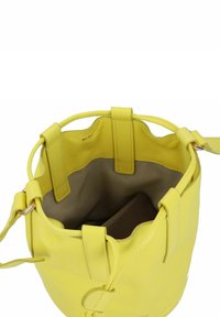Borsa a secchiello gialla in pelle con due manici arrotondati, chiusura a coulisse e fodera interna beige. Presenta una piccola tasca con zip all'interno.