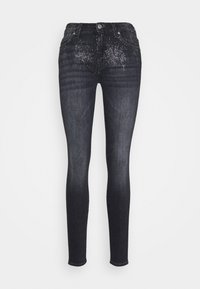 Kapeita kasvat hiukset tummansinisistä farkkuhousuista, joissa on hienovarainen, laikukas kuvio vyötäröllä. Varustettu napilla suljettavalla vyöllä ja perinteisellä viiden taskun muotoilulla.