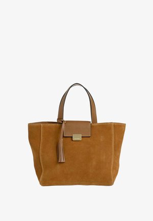 Sac fourre-tout en daim marron avec double poignée, rabat avant avec pompon et petite plaque dorée portant le nom de la marque.