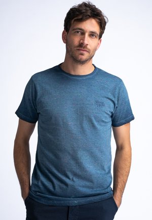 Blauwe gemêleerde katoenen t-shirt met een ronde halslijn en korte mouwen. Kleine logodetail op de borst. Relaxed fit.