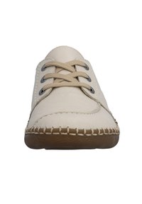 Chaussure en cuir beige avec bout arrondi, lacets beiges et garnitures foncées contrastantes. Semelle en caoutchouc avec une couture visible le long du bord.