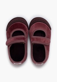 Un paio di scarpette per neonati con cinturini in velcro rosa e suole in gomma scura, viste dall'alto su uno sfondo bianco.