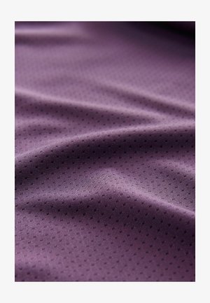 Tissu texturé violet avec une surface lisse et de petits points noirs contrastants, mettant en valeur une qualité douce et fluide ainsi qu'un motif complexe.